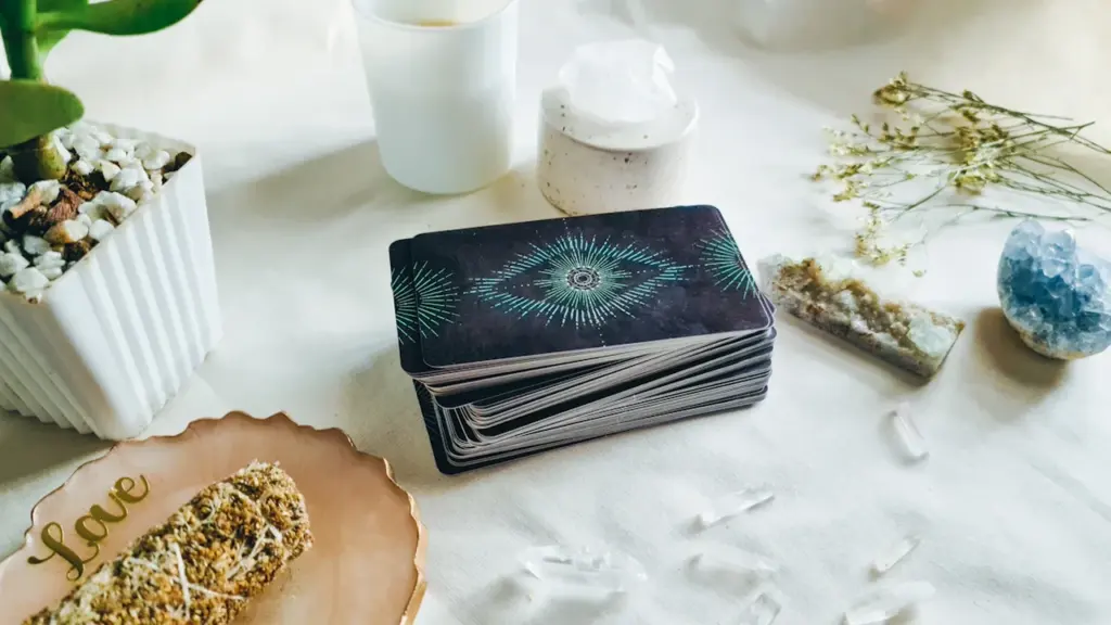 Tarotkarten, Kristalle und Kräuter auf einem Tisch für spirituelle Klarheit und Achtsamkeit.