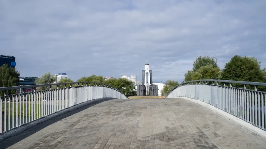Blick über eine Brücke auf ein Denkmal in einer parkähnlichen Umgebung in Minsk.