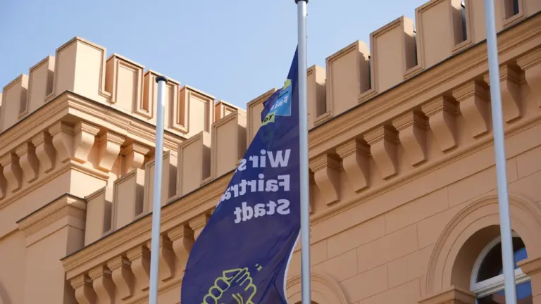 Fahne vor einem historischen Gebäude in einer deutschen Stadt im Sonnenschein.