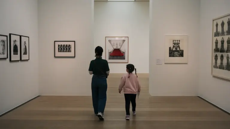 Mutter und Kind beim Besuch einer Kunstausstellung in einem hellen Museum.