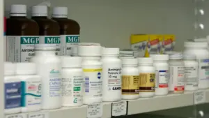 Regale mit verschiedenen Medikamentenpackungen und Flaschen in einer Apotheke.