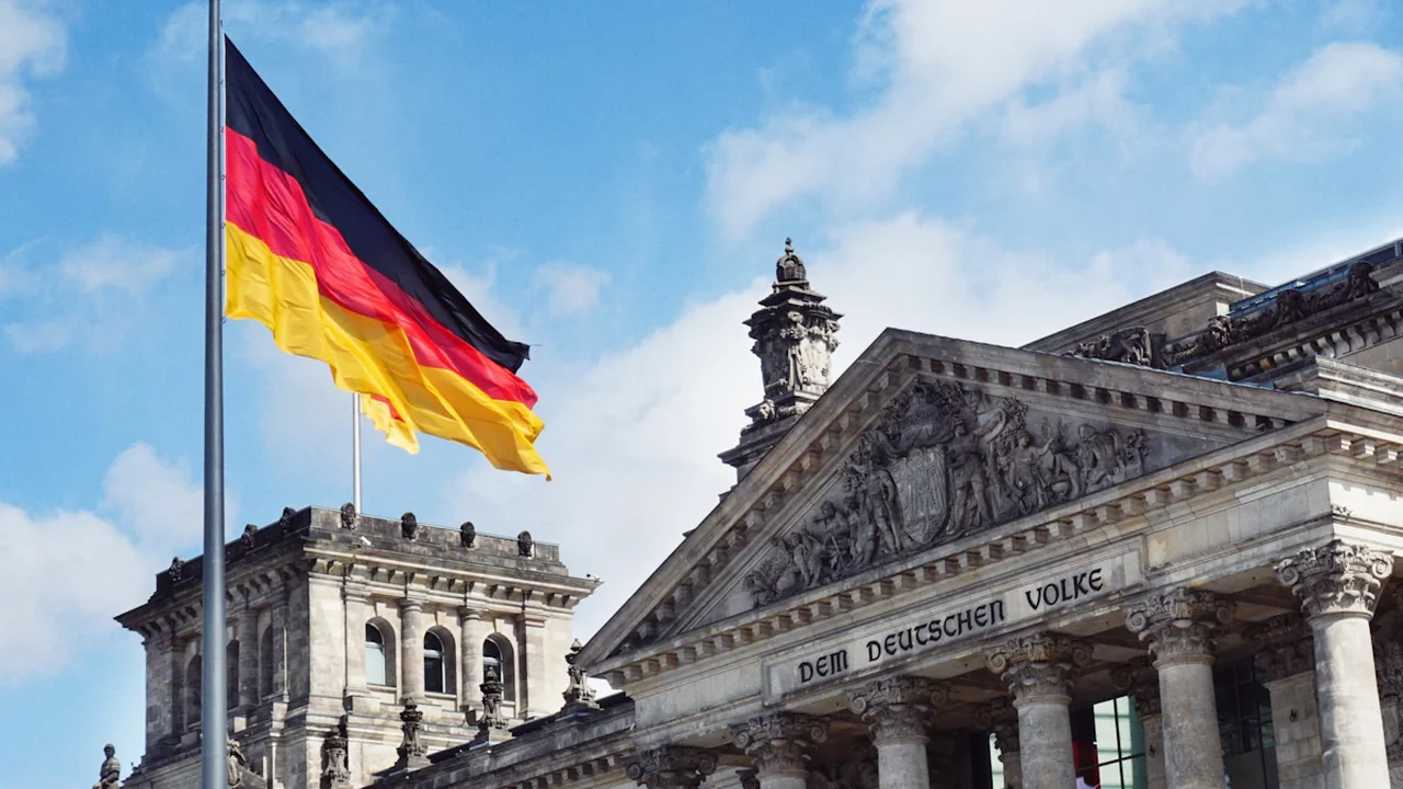 Die deutsche Flagge weht stolz vor dem Reichstagsgebäude in Berlin.