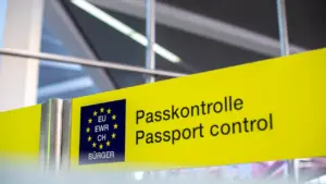 Ein gelbes Schild mit der Aufschrift Passkontrolle für EU-Bürger an einem Flughafen.