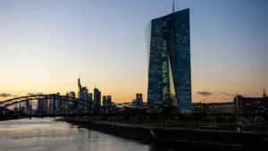 Die Europäische Zentralbank und die Frankfurter Skyline bei Sonnenuntergang von der Brücke aus.