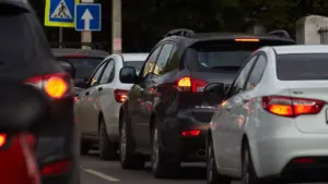Dichte Autoschlange im Stadtverkehr bei Tag mit Verkehrsschildern im Hintergrund