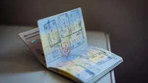 Ein offener Reisepass mit zahlreichen Einreisestempeln liegt auf einem Tisch bereit.