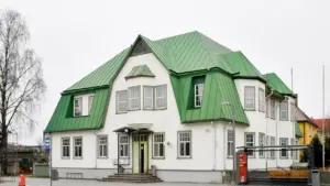 Ein historisches Gebäude mit markantem grünem Dach in einer europäischen Stadt.