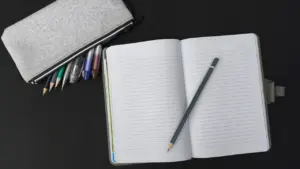 Ein offenes Notizbuch mit Stift auf einem Tisch zur Vorbereitung des Schulstarts.