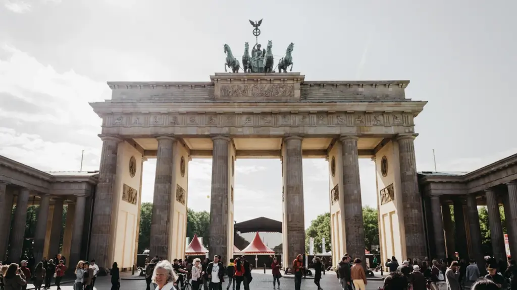 Menschenmenge vor dem Brandenburger Tor in Berlin an einem sonnigen Sommertag.