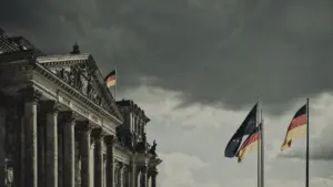 Das Reichstagsgebäude unter einem dramatischen, wolkigen Himmel in Berlin bei Sonnenlicht.