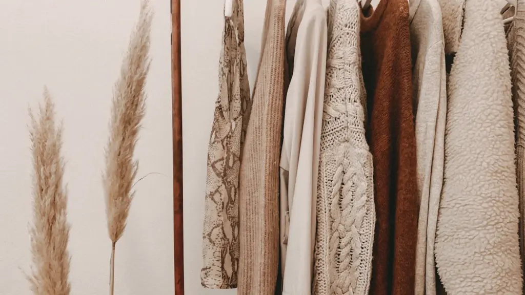Warme Kleidung und Strickpullover hängen ordentlich auf einer Kleiderstange für den Herbst.