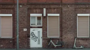 Ein Fahrrad steht vor einem historischen Backsteingebäude in einer deutschen Stadt.