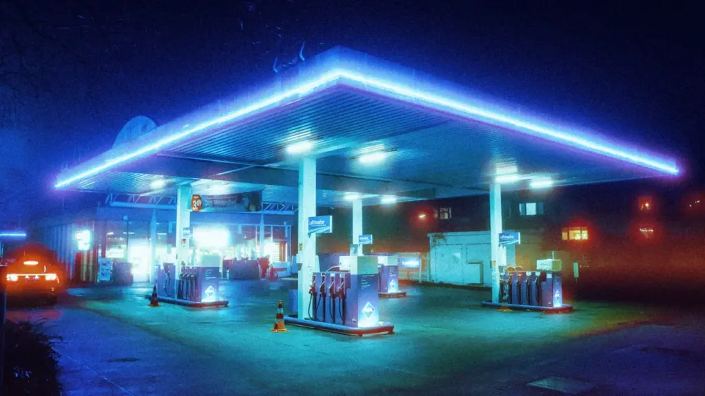 Beleuchtete Aral-Tankstelle in einer nebligen Nacht in Hamburg, Deutschland.