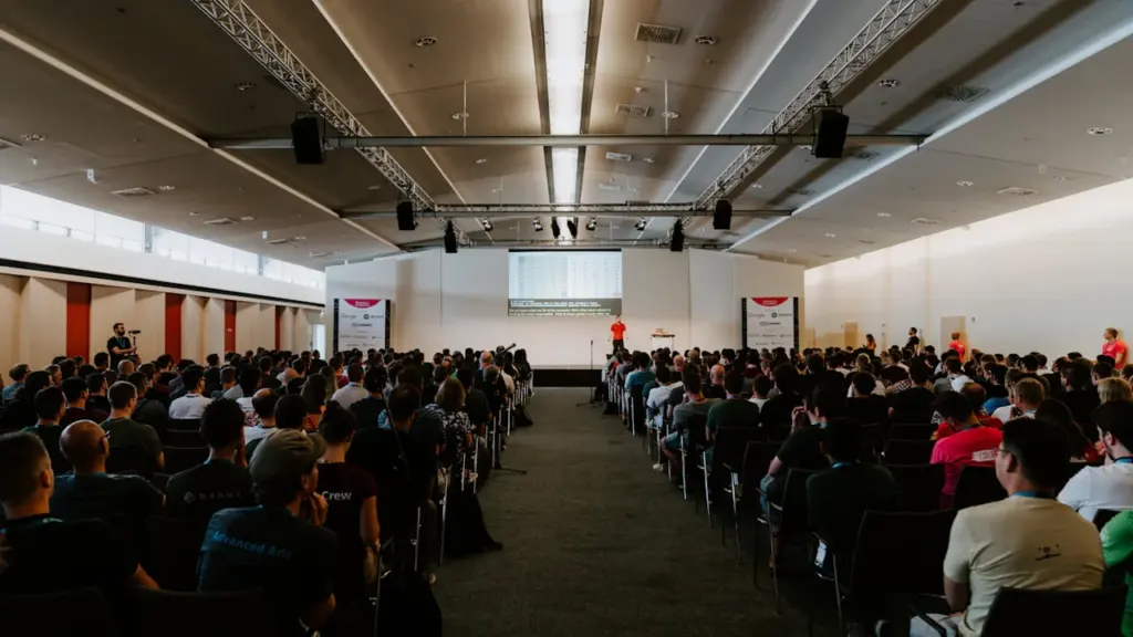 Große Menschenmenge in einem Konferenzsaal während einer professionellen Fachveranstaltung zum Thema Technologie.