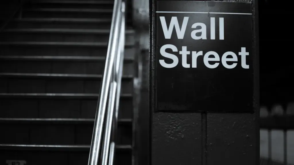 Schwarz-Weiß-Foto eines Wall-Street-Straßenschildes in New York City vor einer Treppe.