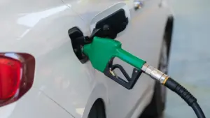 Zapfpistole beim Tanken eines weißen Autos an einer Tankstelle