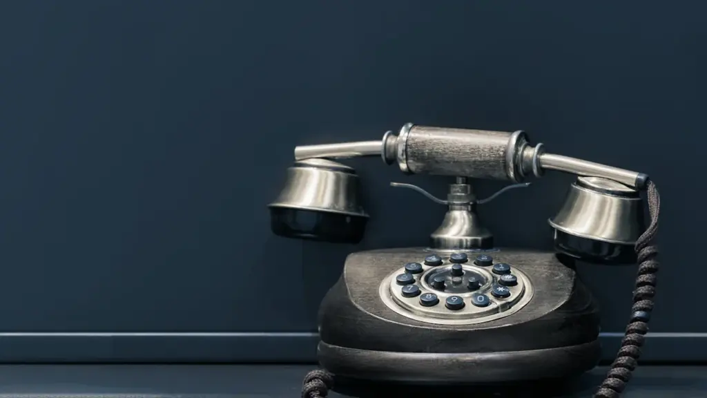 Ein altes schwarzes Telefon vor einem neutralen Hintergrund als Symbol für Telefonbetrug.