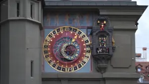 Historische astronomische Uhr an einer Fassade, die astrologische Symbole und Kalenderdaten anzeigt.