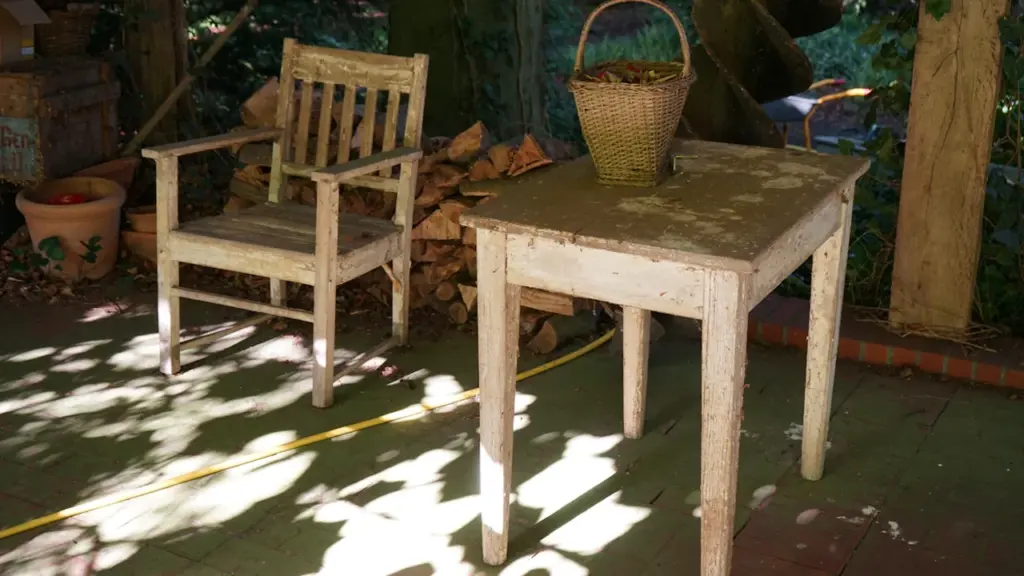 Ein rustikaler Holztisch mit einem Weidenkorb in einem stimmungsvollen Gartenambiente.